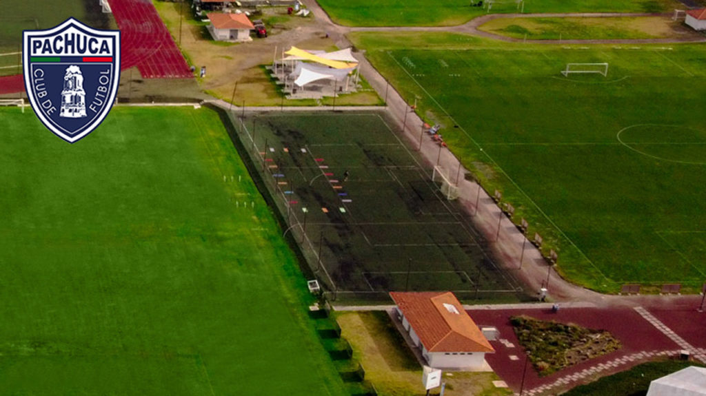 Cancha de pasto sintético equipada con banquillos para dos equipos para uso de la Universidad del Futbol, otros equipos del club y otros usuarios.